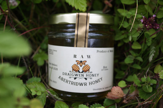 Jar of Draigwenn Honey surrounded by greenery